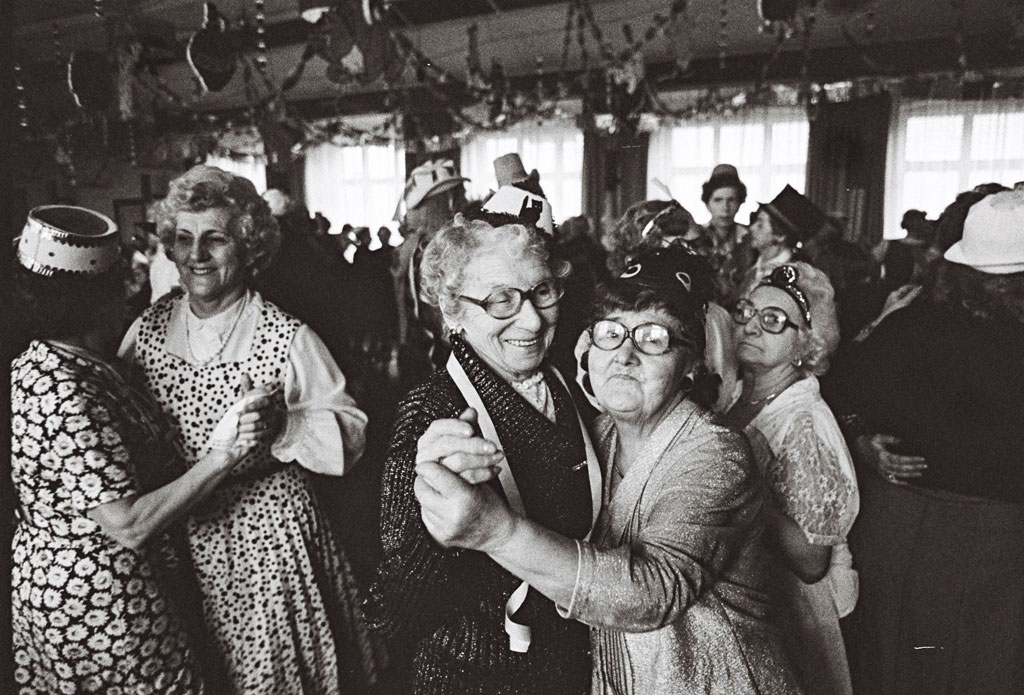 Zwei ältere, verkleidete Damen tanzen miteinander. 