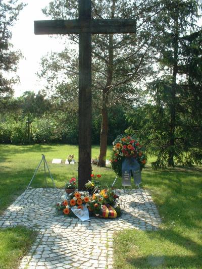 Ein Holzkreuz mit einer Gedenktafel markiert den Beginn der Grabanlage an der Gräberstätte Karnickelberg in Bautzen