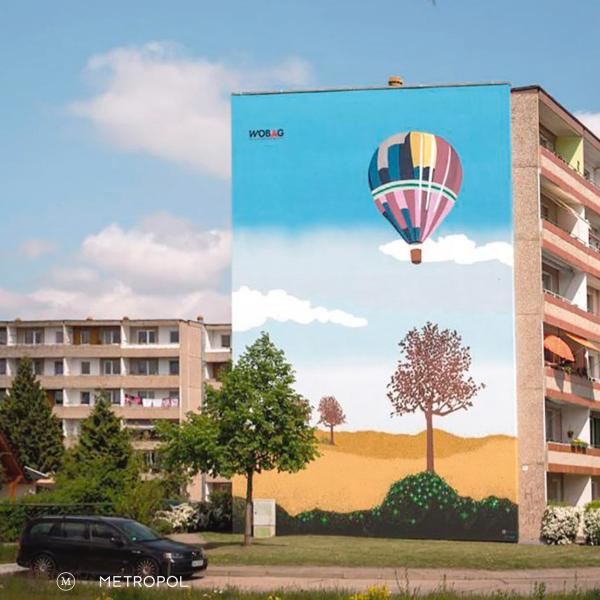 Cover der Publikaktion "DDR im Plural" von Christopher Banditt, Nadine Jenke und Sophie Lange (Hg.) Man sieht eine mit einem Heißluftballon bemalte Fassade