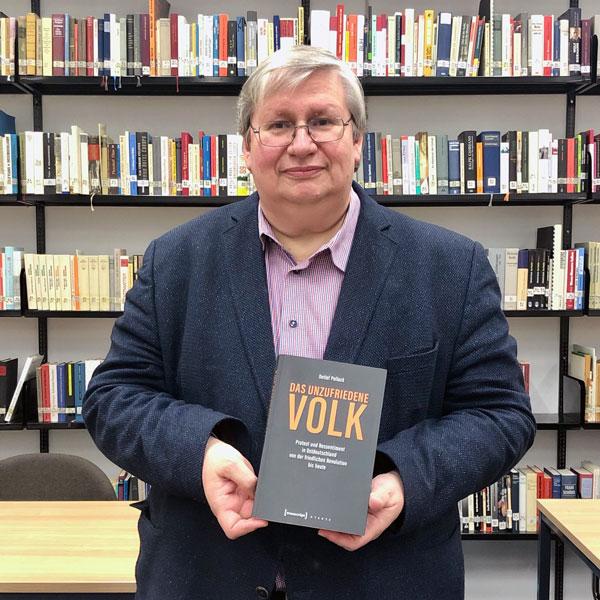 Dr. Frank Hoffmann hölt das Buch "Das unzufriedene Volk" von Detlef Pollak in der Hand.