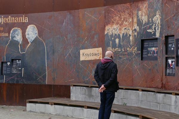 Mann vor einer Ausstellungswand mit Bildern im polnischen Kreisau