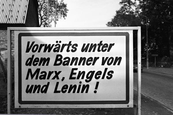 Plakat mit dem Schriftzug "Vorwärts unter dem Banner von Marx, Engels und Lenin!"