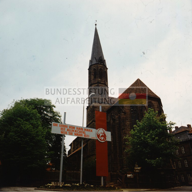 Losung "Die Lehre von Karl Marx / ist Allmächtig, / weil sie wahr ist! (Lenin)" an einer Kirche in Heiligenstadt (Eichsfeld), um 1980. 