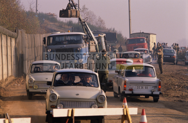 Autoverkehr in beiden Richtungen auf einer unbefestigten Straße entlang der innerdeutschen Grenze in Nähe des Grenzübergangs von Vacha/DDR nach Philippsthal/Hessen (Ost-Seite), 14. oder 15. November 1989.